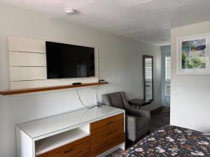 a room with a tv on a wall with a bed at Siesta Inn Sarasota - Indian Beach in Sarasota