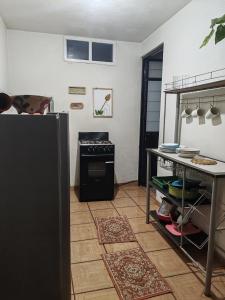 kuchnia z czarną lodówką i stołem w obiekcie Apartment 2 w mieście Santa María Tonantzintla +3 zdjęcia