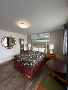 a hotel room with a bed and a table and a chair at Siesta Inn Sarasota - Indian Beach in Sarasota