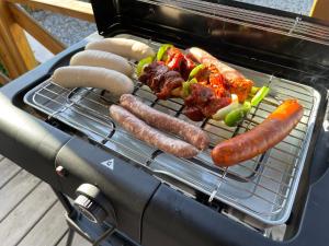 a grill with sausages and other food on it at Chalet Chez Nous Castellane in Castellane