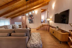 a living room with a couch and a flat screen tv at Maleme Maisonette in Maleme