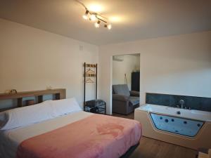 a bedroom with a bed and a bathroom with a tub at Verde in Alcalá del Júcar