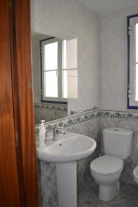 a bathroom with a sink and a toilet and a mirror at Andar com jardim e estacionamento in Paço de Arcos