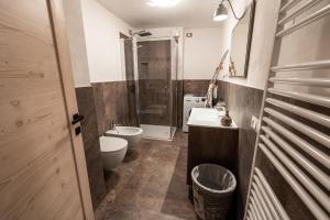 a bathroom with a toilet and a sink and a shower at Casa Marzari Lavarone - Appartamento Ginepro in Chiesa