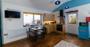 a kitchen with a table and chairs in it at Skye Blue Bothy in Teangue