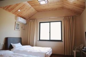 sypialnia z 2 łóżkami i oknem w obiekcie The Zhang B&B w mieście Tiantai