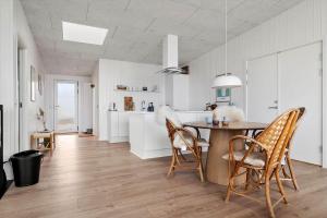 a white kitchen with a table and chairs at 20428-Samso-Radyrvej-10 in Langemark +21 photos