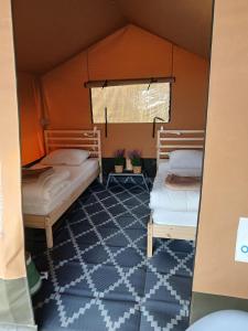 a room with two beds in a tent at Safaritent 4 in Biddinghuizen
