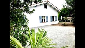 a white house with a window on the side of it at Maison individuelle Hourtin centre jardin clos in Hourtin