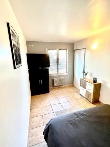 a bedroom with a bed and a tiled floor at Maison individuelle Hourtin centre jardin clos in Hourtin