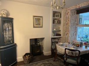 a dining room with a table and a fireplace at Glan Morfa in Morfa Nefyn