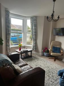 a living room with a couch and a table and a window at Glan Morfa in Morfa Nefyn