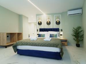 a bedroom with a large bed with two towels on it at Ernest Suites Psiri in Athens +108 photos