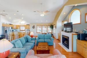 a living room with a blue couch and a fireplace at Dune Deck in Corolla