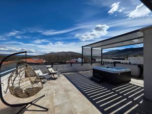a patio with a hot tub and a grill on a roof at Penthouse Olivia Sky Residence in Međugorje