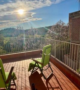 a balcony with two green chairs and a view at Cal Isabel in Pobla de Montornés