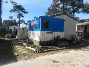a house with a blue cover on the side of it at Le mobil home bleu ! Camping Naturiste in Montalivet-les-Bains