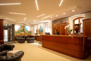 a woman sitting at a reception desk in a lobby at Hotel Duomo - Etruria Collection in Orvieto