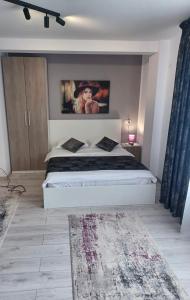 a bedroom with a bed with a picture of a woman at Aparthotel Oltului in Galaţi +14 photos