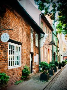 a brick building with potted plants on a street at Suite Dreams Bremen in Bremen