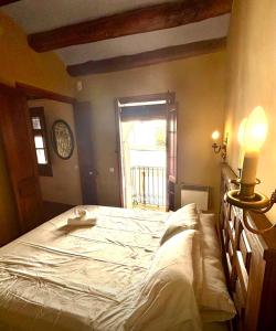 a bedroom with a large bed with a window at Cal Isabel in Pobla de Montornés