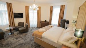 a hotel room with a large bed and a chair at Hotel Fatima in Trenčín