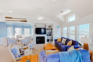 a living room with a blue couch and a fireplace at Sandcastle in Corolla