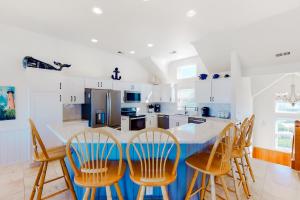a kitchen with a table and chairs in it at Sandcastle in Corolla