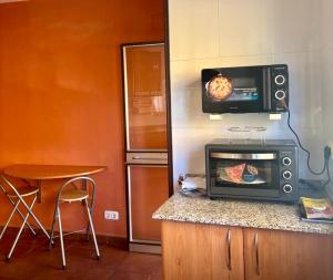 a kitchen with a stove and a tv on the wall at Cal Isabel in Pobla de Montornés