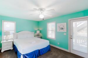 a bedroom with a white bed and blue walls at Sandcastle in Corolla +63 photos
