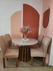 a table with two chairs and a vase with flowers on it at Raízes do Sertão - Vale do Catimbau in Buíque