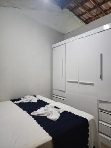 a bedroom with a bed with white cabinets and white towels at Raízes do Sertão - Vale do Catimbau in Buíque