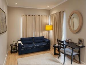 a living room with a blue couch and a table at Stylish 2, 3 and 5 Bedroom Entire Homes Near Art Deco and LA Hotspots in Los Angeles