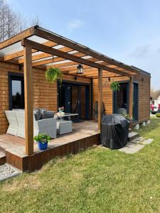 a wooden pergola on a deck in a yard at Domki La Bella 3 in Aleksandria