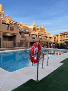 a swimming pool with a red slide in front of a building at playa ancha in San Luis de Sabinillas