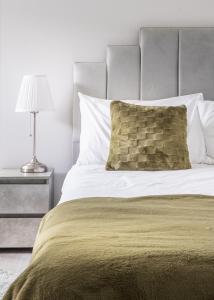 a bedroom with a bed with a pillow and a lamp at Jasmin Place in Luton