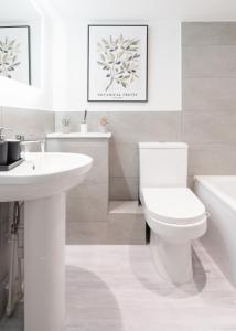 a white bathroom with a toilet and a sink at Jasmin Place in Luton +13 photos