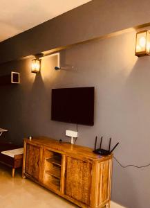 a living room with a television on a wall at Skyline Serenity by Vantage View in Nalmatha