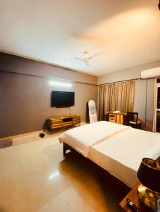 a bedroom with a large bed and a flat screen tv at Skyline Serenity by Vantage View in Nalmatha