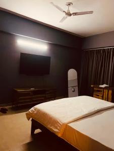 a bedroom with a bed and a flat screen tv at Skyline Serenity by Vantage View in Nalmatha