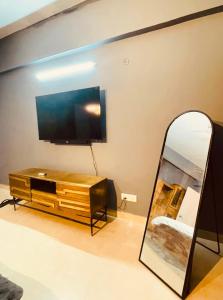a living room with a television and a mirror at Skyline Serenity by Vantage View in Nalmatha