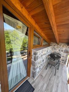 a balcony with a table and a glass door at Bujtina Carku in Theth