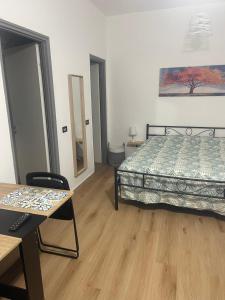 a bedroom with a bed and a table and a chair at La Casuzza del Borgo in Agrigento