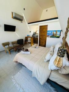 a bedroom with a large bed and a living room at Andinas de Uco Lodge in La Consulta
