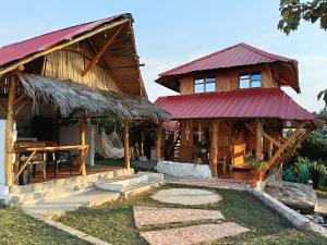 a wooden house with a red roof at Wila Hostal in Gigante