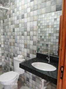 a bathroom with a toilet and a sink at Casa PA parque das aguas in Bonito