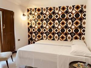 a bedroom with a large white bed with a wall at Villa dei Filari in Tramonti +5 photos