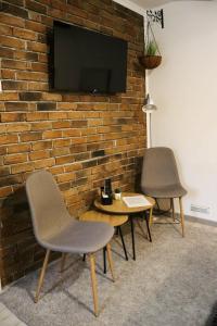 two chairs and a table in front of a brick wall at Nordic Dream Apartment in Kikinda in Kikinda