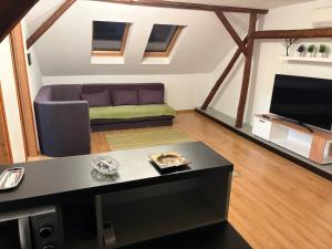 a living room with a couch and a tv at Comfy Attic in Pančevo