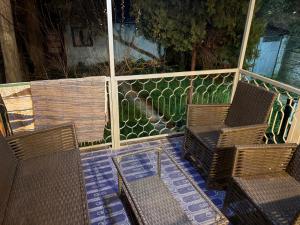 two chairs and a table on a porch with a fence at Comfy Attic in Pančevo